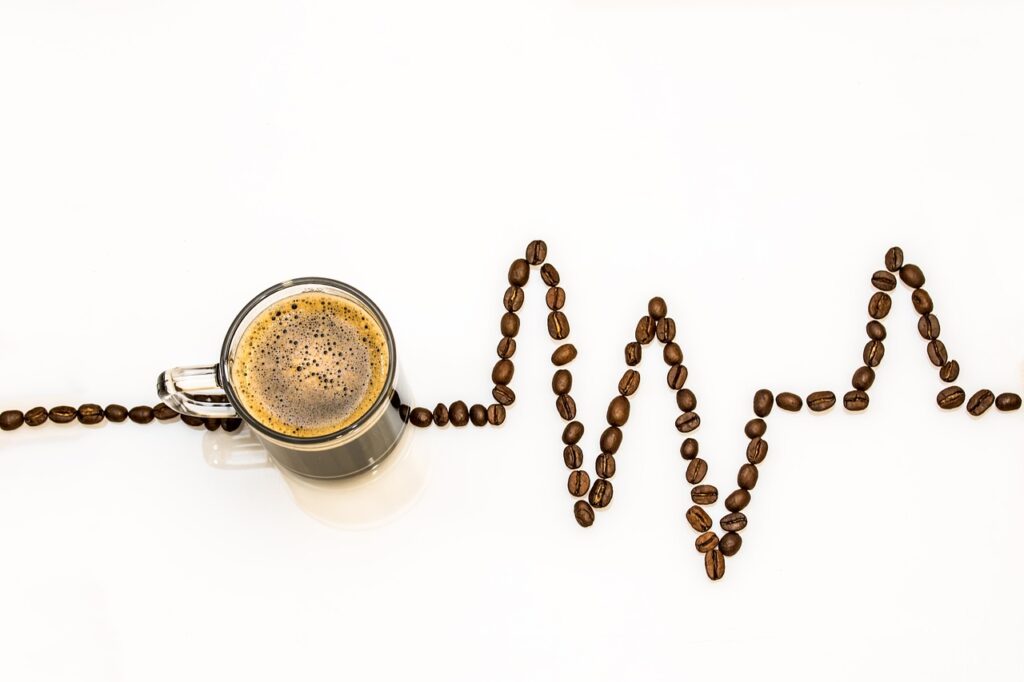 Coffee beans symbolizing a heartbeat with a transparent cup filled with coffee