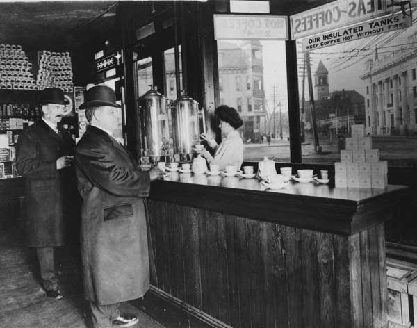 Historical image of woman serving men coffee in Cambridge, Massachusetts, USA in 1910s