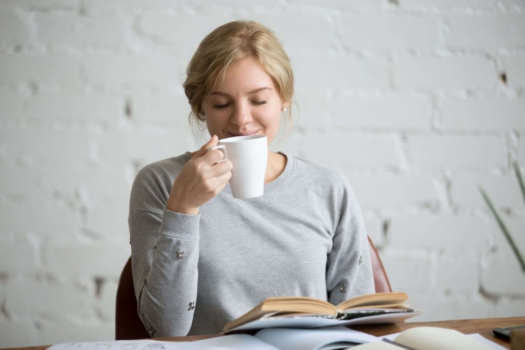 Woman enjoying a fresh mug of coffee made with a best value coffee machine with top features